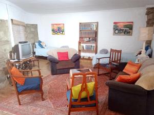 a living room filled with furniture and a tv at Rheola's Guest Cottage in Harrismith