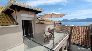 a balcony with a table and an umbrella at Holiday Lefkas Sunrise Luxury Appartments in Nikiana