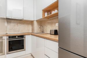 a kitchen with white cabinets and a stainless steel refrigerator at Central One-Bedroom Apartment in Budva