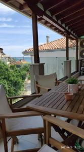 a wooden table and chairs on a patio at Holiday Lefkas Sunrise Luxury Appartments in Nikiana