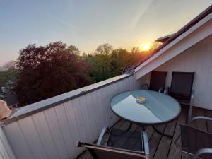 einen Tisch und Stühle auf einem Balkon mit Blick auf den Sonnenuntergang in der Unterkunft Fewo, 55 qm, voll ausgestattet, mit Süd-Loggia, Nähe Völkerschlachtdenkmal in Leipzig
