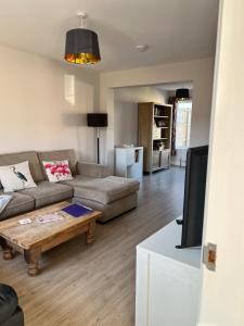 a living room with a couch and a coffee table at Bright and airy 3 bedroom home near southwold in Wangford