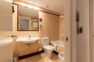 a bathroom with a toilet and a sink and a tub at Alda Centro Zaragoza in Zaragoza