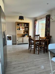 a living room with a dining room table and chairs at Bright and airy 3 bedroom home near southwold in Wangford