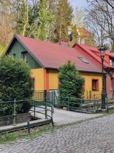 un bâtiment jaune et vert avec un toit rouge dans l'établissement Apartamenty Magiczna Wenecja, à Cieszyn