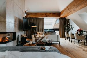 a room with a bed, a chair, a table and a window at DO & CO Hotel München in Munich
