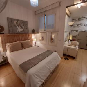 Un dormitorio con una gran cama blanca y una lámpara. en Habitacion en apartamento Vegueta, en Las Palmas de Gran Canaria