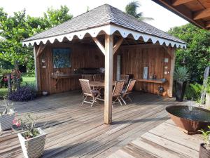 a wooden gazebo with a table and chairs on a deck at CAP 8 in Le Marin