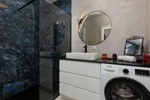 een badkamer met een wasmachine en een spiegel bij SOHO 18 Apartment by Renters Prestige in Warschau