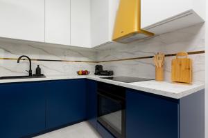 een keuken met blauwe kasten en een wastafel bij SOHO 18 Apartment by Renters Prestige in Warschau