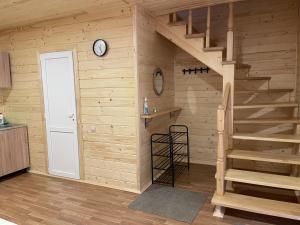 a room with a wooden wall with a staircase and a clock at Медові Карпати in Oryavchyk