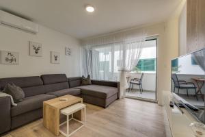 a living room with a couch and a table at Apartmani Bella Luce in Pašman