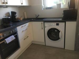 a kitchen with a washing machine and a sink at Exklusives Apartment in Bad Säckingen für 2 Person in Bad Säckingen