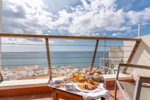 a breakfast table on a balcony with a view of the ocean at Boa Vista Hotel & Spa - Adults Only in Albufeira