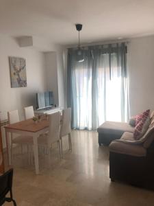 salon ze stołem i kanapą w obiekcie Apartamento Maracena C/ Ramón y Cajal w mieście Maracena