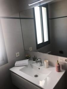 łazienka z umywalką i dużym lustrem w obiekcie Apartamento Maracena C/ Ramón y Cajal w mieście Maracena