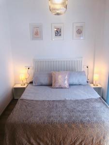 a bedroom with a large bed with two lamps at Apartamento Maracena C/ Ramón y Cajal in Maracena