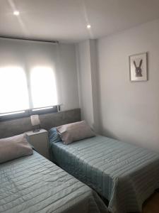 sypialnia z dwoma łóżkami i obrazem na ścianie w obiekcie Apartamento Maracena C/ Ramón y Cajal w mieście Maracena +3 zdjęcia