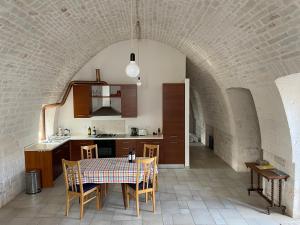 kuchnia i jadalnia ze stołem i krzesłami w obiekcie Casa Trieste w Alberobello