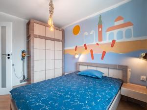 - une chambre avec un lit bleu et un mur orné d'une fresque murale dans l'établissement Apartament Bursztynowy Nowy, à Sopot