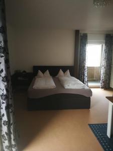 
a bedroom with a large bed and a large window at Kurhotel Luitpold in Bad Wörishofen
