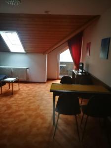 
a room with a table, chairs and a window at Kurhotel Luitpold in Bad Wörishofen
