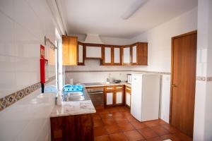 a kitchen with a sink and a refrigerator at Downtown PDL in Ponta Delgada