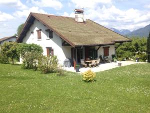 a small white house in a field of grass at La maison des Bleuets in Saint-Jorioz