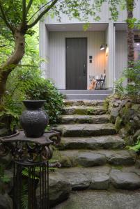 un vase assis sur une table devant une maison dans l'établissement Hakone Mori No Yado, à Hakone