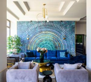 a living room with a blue couch and a blue wall at Hotel Rogge in Reşiţa