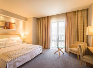 a hotel room with a bed and a window at Hotel Rogge in Reşiţa