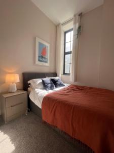 a bedroom with a large bed and a window at The Cornish Bank Flats in Falmouth