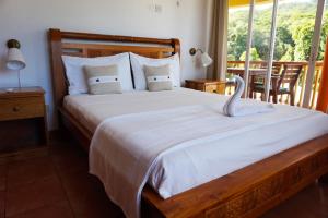 1 dormitorio con 1 cama grande y ventana grande en La Villa Therese, en Anse Royale