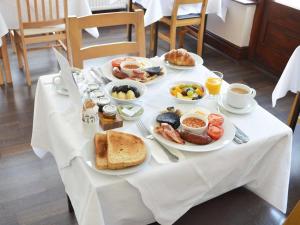 una mesa con platos de comida para el desayuno. en East Lyn House en Lynmouth