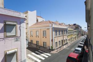 リスボンにあるFLH - Charming Graça Duplexの路上に停められた建物や車が並ぶ街道