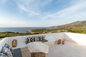 Kalliston Naxos في أكروتيري: أريكة بيضاء تجلس على شرفة تطل على المحيط