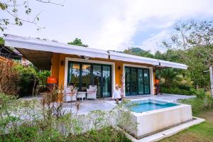 a person standing in front of a house with a pool at Bungalow VILLA Rumba in Ko Yao Noi