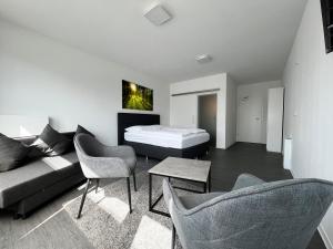 Nordwaldekleines boardinghouse的客厅配有床、沙发和椅子