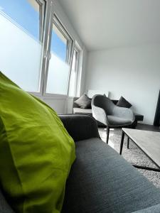 uma sala de estar com um sofá e duas cadeiras em kleines boardinghouse em Nordwalde