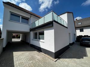 a white house with a glass roof and a driveway at kleines boardinghouse in Nordwalde