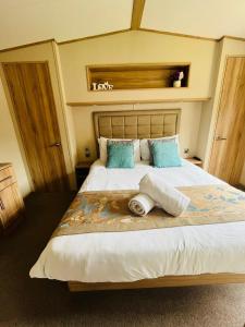 a bedroom with a large bed with two towels on it at Brooksbank Lodge with Hot Tub in Barmby on the Moor