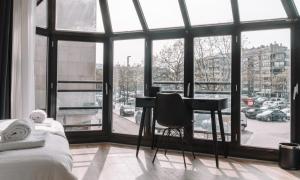 - une chambre avec un bureau en face d'une grande fenêtre dans l'établissement Hotel Cavalli by WP Hotels, à Blankenberge