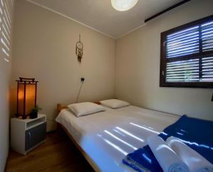 ein Schlafzimmer mit einem großen weißen Bett und einem Fenster in der Unterkunft Privát Bungaló 5 perc sétára a mólótól in Révfülöp