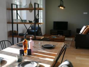 een woonkamer met een tafel met een fles wijn bij Hôtel-Spa Domaine de Diane in Quend