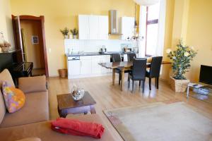 Una sala de estar y una cocina con mesa y sillas. en Villa Medici App_ 02, en Ahlbeck