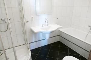 Un baño con lavabo, inodoro y ducha. en Villa Medici App_ 02, en Ahlbeck
