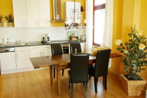 Una cocina con una mesa de madera y sillas negras. en Villa Medici App_ 02, en Ahlbeck
