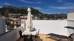 a patio with a table and chairs and an umbrella at Gemütliches Altstadthaus am Kirchplatz in Calpe in Calpe