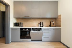 a kitchen with white cabinets and a stove top oven at Family Holiday House VIKING - Garden, Playground & Grill by Noclegi Renters in Kołczewo