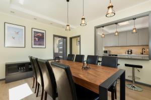 a dining room with a wooden table and chairs at Family Holiday House VIKING - Garden, Playground & Grill by Noclegi Renters in Kołczewo